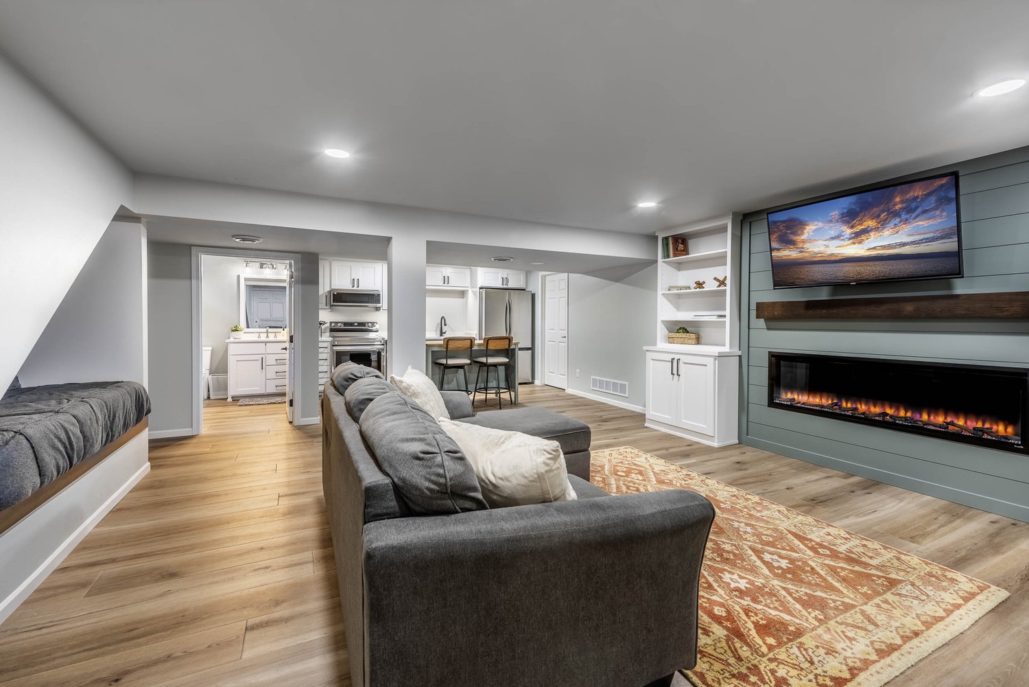 Finished basement renovation with new flooring, recessed lighting, and custom built-ins by Robin Construction in Novi, MI