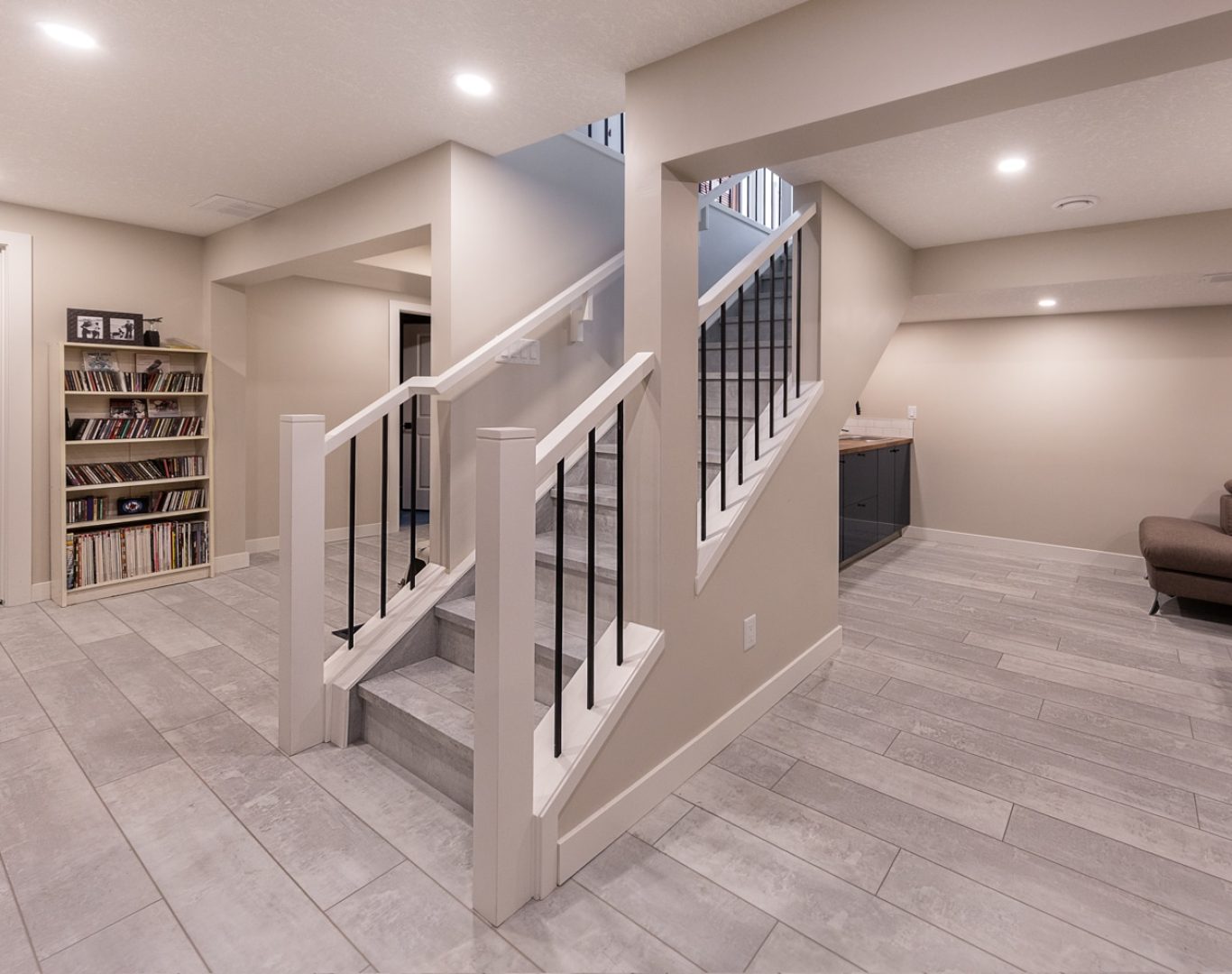 Finished basement renovation with new flooring, recessed lighting, and custom built-ins by Robin Construction in Novi, MI